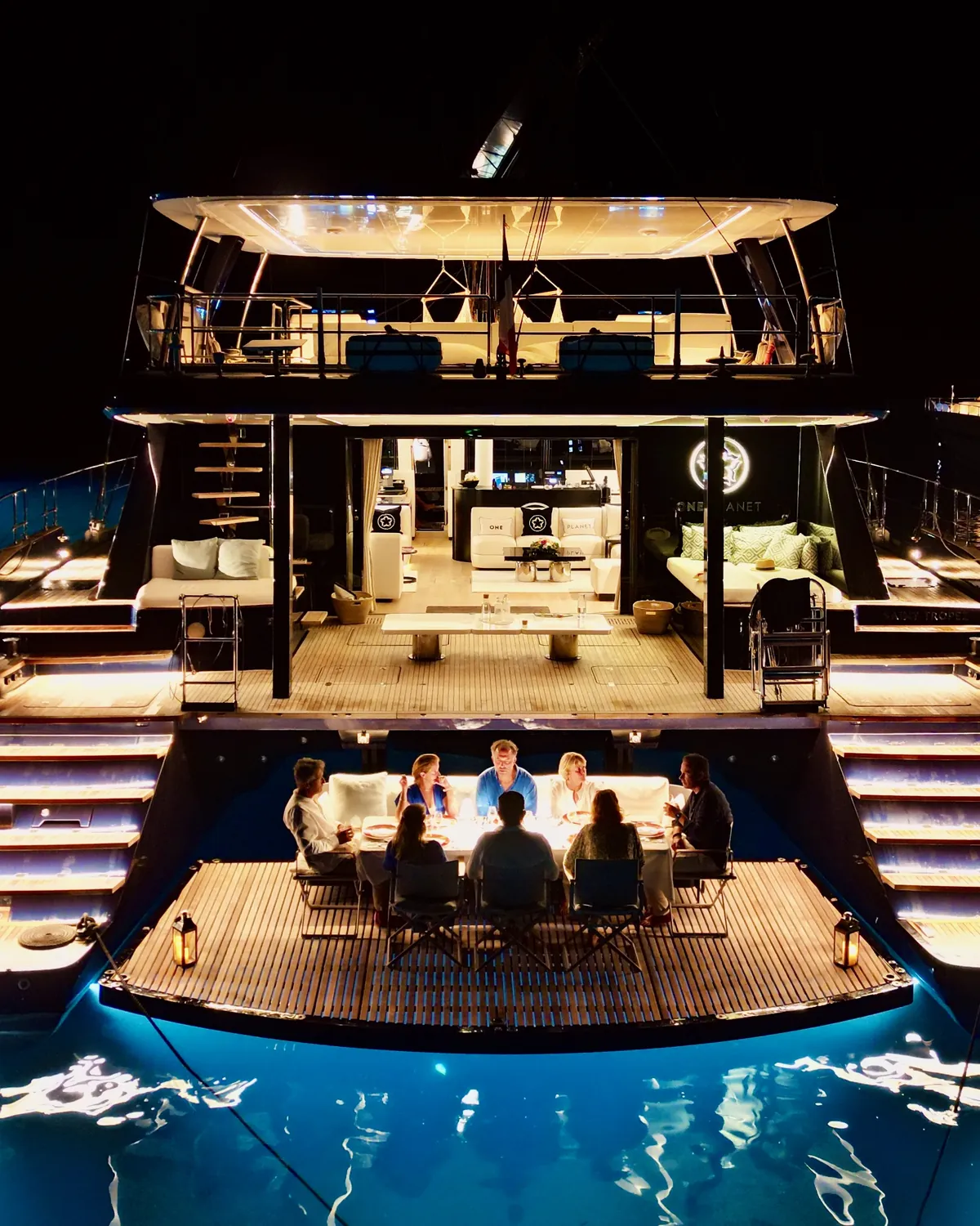 Dinner at sea level on One Planet’s beach club, lit by underwater lights
