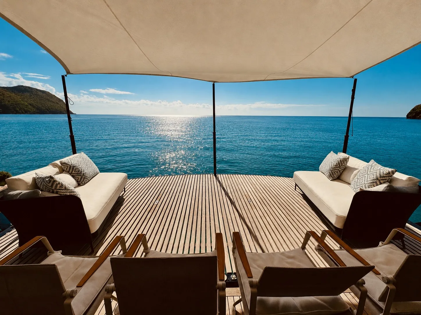 One Planet’s aft terrace with sofas under the awning, open to the sea