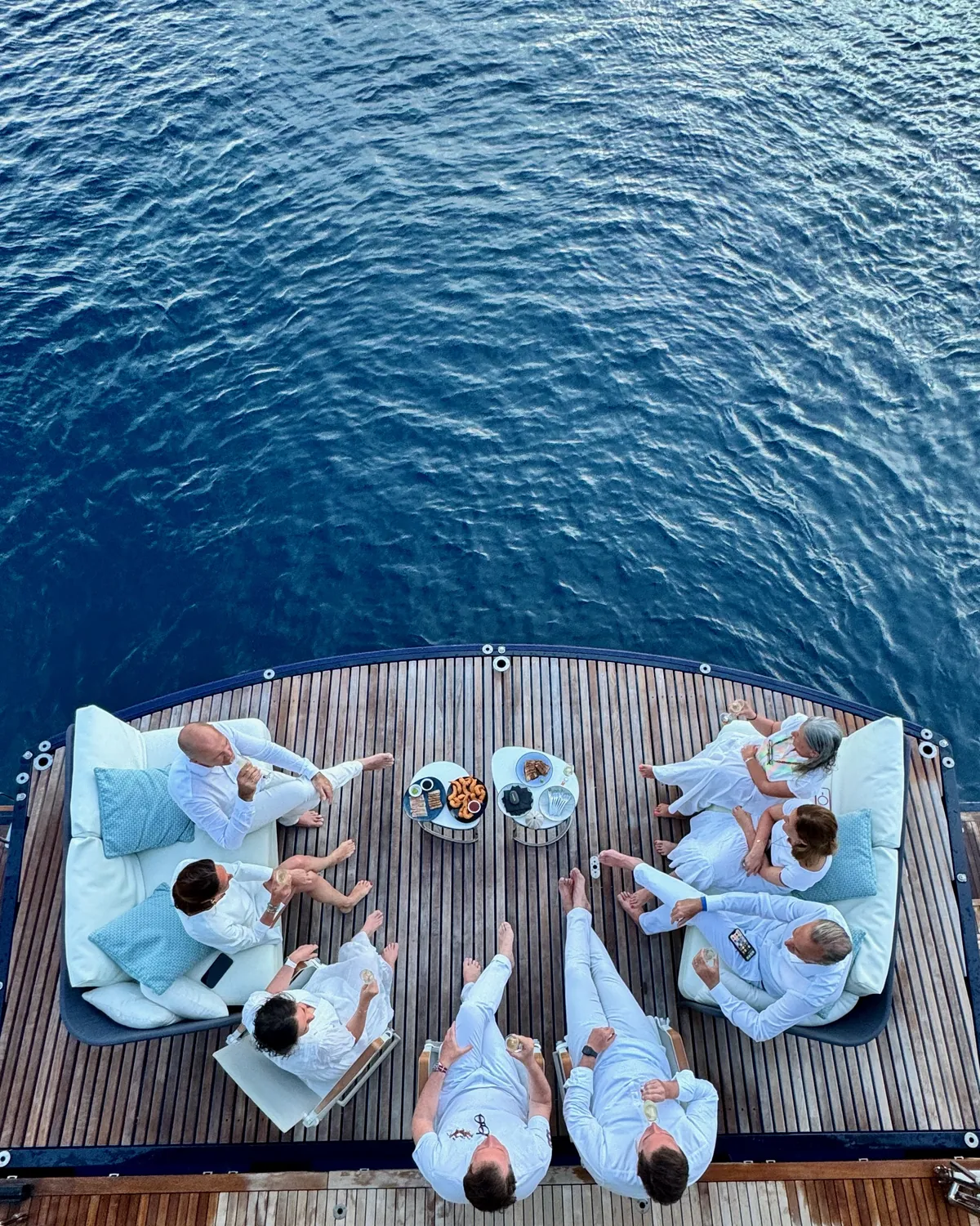 Guests in white relaxing on One Planet’s front terrace, seen from above