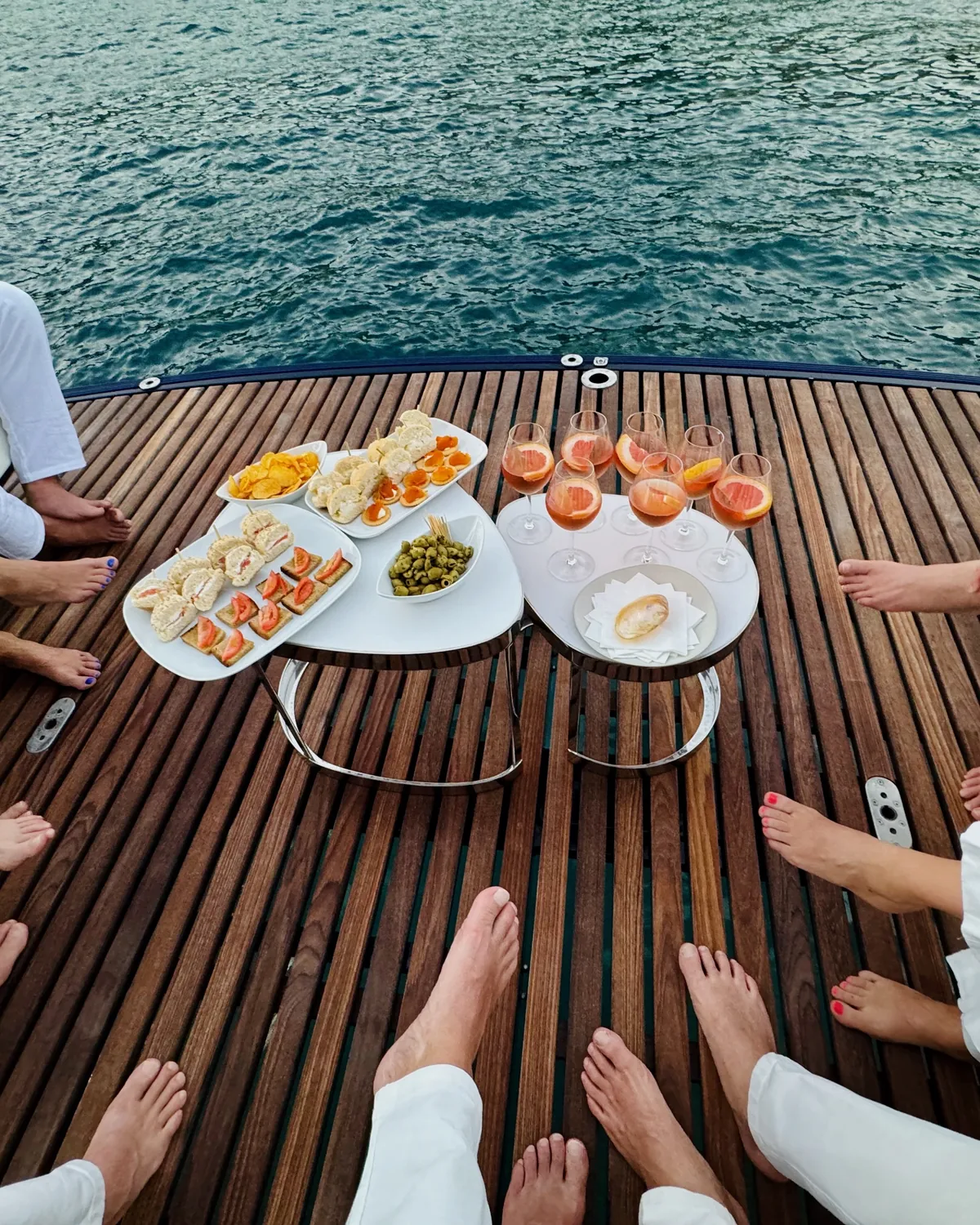 Guests sharing an aperitif on One Planet’s teak deck