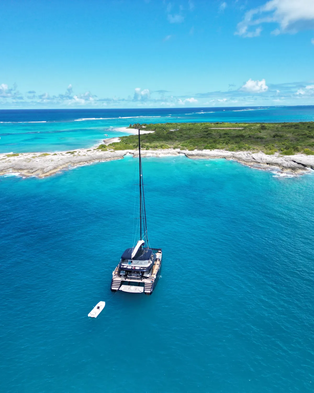 One Planet at anchor off a white-sand Caribbean island