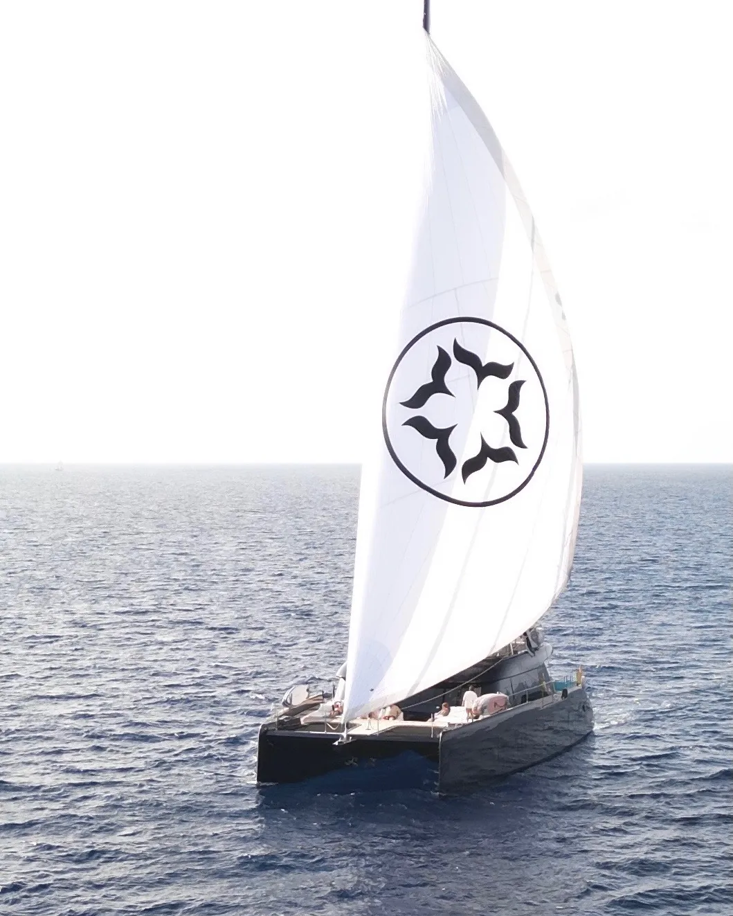 One Planet under sail, her star logo on the headsail